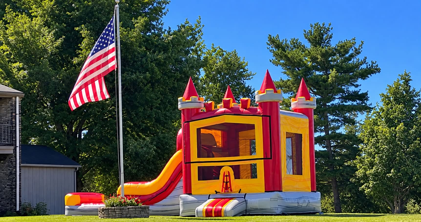 Red and yellow castle bounce house with a slide set up outdoors